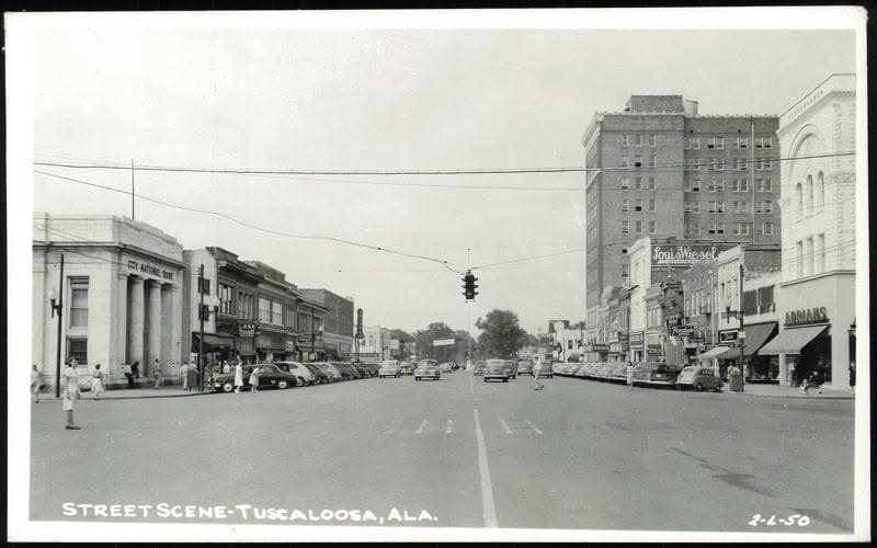 A 1950 photograph of Greensboro Avenue in downtown Tuscaloosa, Alabama, with period cars parked along the storefronts